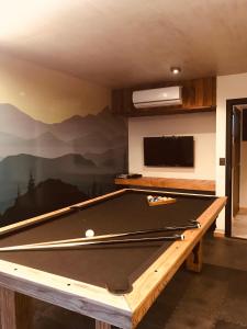 una mesa de ping pong en una habitación con pared en AIKEN JARDIN con cochera en San Martín de los Andes