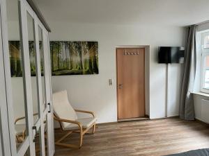 a room with a chair and a television and a door at Ferienhaus Harzcolor Wernigerode in Wernigerode