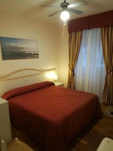 セストリ・レヴァンテにあるDimora Tipica Appartamentoのベッドルーム1室(赤いベッド1台、天井ファン付)