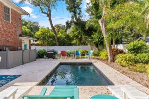 un patio trasero con una piscina con sillas y una mesa en Lega-Sea 4210 Tenth Street East, en Saint Simons Island