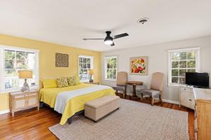 1 dormitorio con cama amarilla y TV en Lega-Sea 4210 Tenth Street East, en Saint Simons Island
