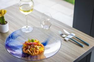 a plate of pasta and a glass of wine on a table at Best Western Plus Sabaudia Hotel in Sabaudia