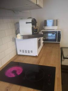 a kitchen with a microwave and a purple plate on the floor at Studio Neuilly Paris La Défense in Neuilly-sur-Seine