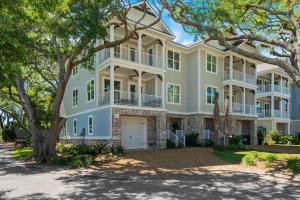 a large white house with trees in front of it at Viewpoint Oaks - 301 7th Street, Unit 101 in Saint Simons