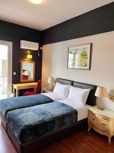 um quarto com uma cama grande e uma cadeira vermelha em Queens Leriotis Hotel em Pireu