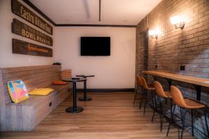 a bar with stools and a tv on the wall at Amsterdam Hostel in San Francisco