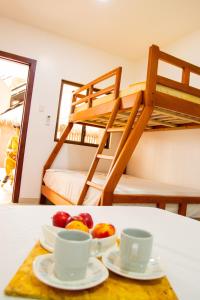阿揚奎的住宿－HOTEL SEAHORSE AYANGUE，桌子上两杯和一碗水果,配有双层床