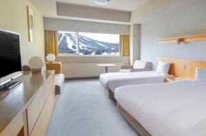 a hotel room with two beds and a flat screen tv at ANA Crowne Plaza Resort Appi Kogen, an IHG Hotel in Hachimantai