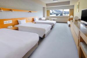 ANA Crowne Plaza Resort Appi Kogen, an IHG Hotel في Hachimantai: غرفه فندقيه اربع اسره وتلفزيون