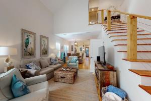sala de estar con sofá y escalera en Coastal Comfort - 108 Fish Fever Lane, en Saint Simons