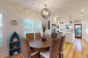 une cuisine et une salle à manger avec une table et des chaises en bois dans l'établissement Coastal Comfort - 108 Fish Fever Lane, à Saint Simons