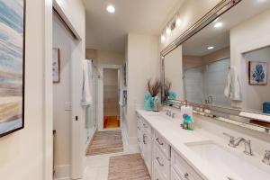 une salle de bain avec deux lavabos et un grand miroir dans l'établissement Coastal Comfort - 108 Fish Fever Lane, à Saint Simons 20 autres photos