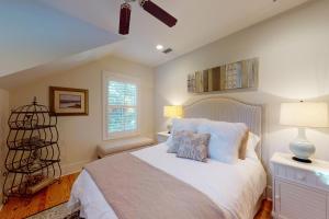 1 dormitorio con 1 cama blanca grande y ventana en Coastal Comfort - 108 Fish Fever Lane, en Saint Simons