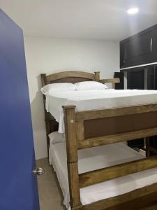 a bedroom with a bunk bed with white sheets at Tu hogar en Cali Apto centrico cómodo y privado in Cali