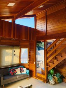 a living room with a couch and a staircase in a house at Chalé Vale da Mata - São Roque SP in São Roque