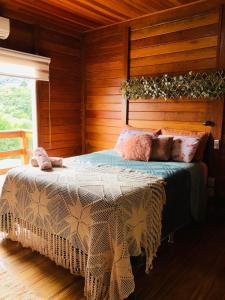 a bedroom with a bed in a wooden cabin at Chalé Vale da Mata - São Roque SP in São Roque