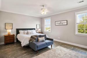 ein Schlafzimmer mit einem Bett und einem Stuhl und Fenstern in der Unterkunft Walk'n on Sunshine - 19 Hendrix Walk in East End + 42 Fotos