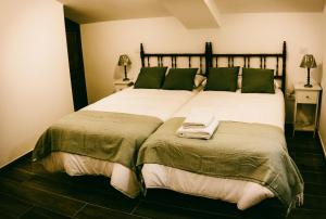 1 dormitorio con 1 cama blanca grande con almohadas verdes en El Aprisco, con piscina climatizada en Hueva-Guadalajara, en Hueva