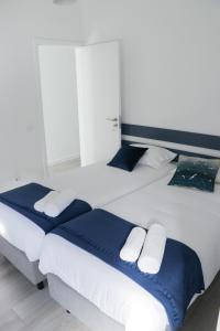 dwa łóżka z niebieską i białą pościelą w sypialni w obiekcie Perto do Mar, Alojamento Local w mieście Gafanha da Boa Hora