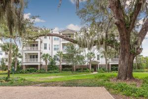 ein großes weißes Gebäude mit einem Baum davor in der Unterkunft The Villas at Gascoigne - 117 Gascoigne Ave, #305 in Saint Simon Mills