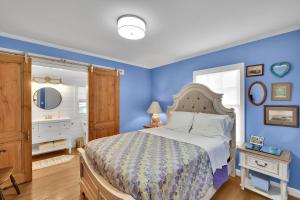 ein Schlafzimmer mit einem Bett und einer blauen Wand in der Unterkunft Happy Cottage - 504 Sea Breeze Dr in Demere Park