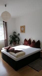 a bedroom with a large bed with white sheets and red pillows at Ferienwohnung Maks und Kris in St. Andrä am Zicksee