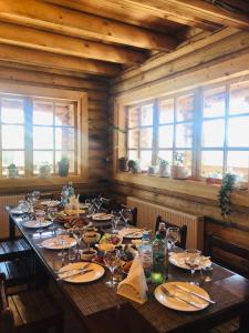 a dining room with a long table with chairs and windows at Mate's Shack in Khulo +32 photos