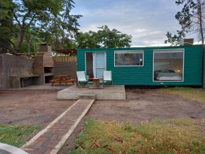 una casita verde pequeña con mesa y sillas en Rinconadita en San Pedro