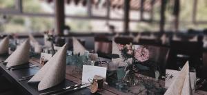 - une table avec des fleurs et des bateaux en papier dans l'établissement Restaurant & Hotel Zur Falkenhöhe, à Falkenau