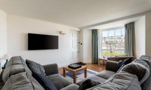 ein Wohnzimmer mit einem Sofa und einem Flachbild-TV in der Unterkunft Coral in Brixham
