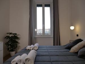 een slaapkamer met een blauw bed en handdoeken bij Prada Home Milano in Milaan
