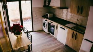 a kitchen with a table and a washing machine at El Aprisco, con piscina climatizada en Hueva-Guadalajara in Hueva