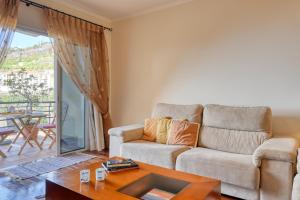 a living room with a couch and a table at Lidia's Place, a Home in Madeira in Ponta do Sol