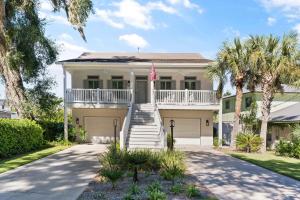 ein weißes Haus mit Palmen und einer Flagge in der Unterkunft Beach Chickens - 1019 Mallery Street in Mallory Park