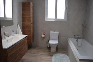 a bathroom with a tub and a toilet and a sink at Lovely 3-bedroom apartment in L-Iklin in LʼInglin