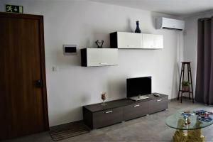 uma sala de estar com uma televisão e uma mesa de vidro em Lovely 3-bedroom apartment in L-Iklin em Iklin