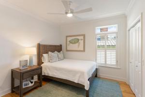 ein Schlafzimmer mit einem Bett und einem Deckenventilator in der Unterkunft Beach Chickens - 1019 Mallery Street in Mallory Park + 22 Fotos