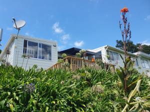 a house with a garden in front of it at Stanmore Bay Beachfront Cottage in Whangaparaoa