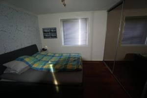 a bedroom with a bed with a plaid blanket on it at Apartement in Drammen close to the main city in Drammen