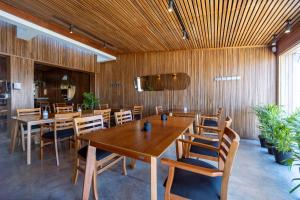 Nobile Hotel Montoya في بونتا دل إستي: غرفة طعام بجدران خشبية وطاولات وكراسي خشبية