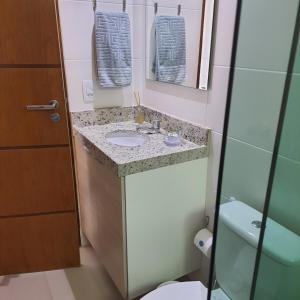 a bathroom with a sink and a toilet and a mirror at Apt. 612 in Cabedelo