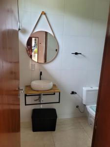 ein Bad mit einem Waschbecken und einem Spiegel in der Unterkunft POUSADA Chacara ENTRE NÓS in Holambra
