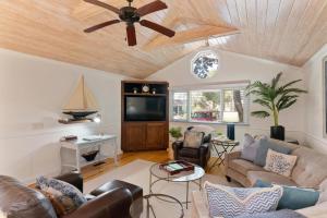 a living room with a couch and a ceiling fan at Live Oak Retreat - 2104 Bruce Drive in Saint Simons Island