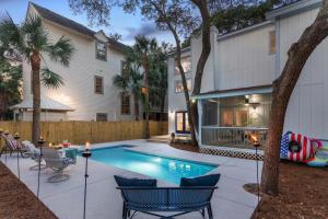 a backyard with a swimming pool and a house at Live Oak Retreat - 2104 Bruce Drive in Saint Simons Island