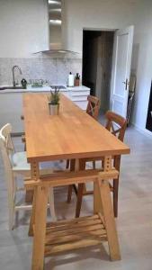 Alojamiento privado en casa de montaña في Matadepera: طاولة وكراسي خشبية في مطبخ مع حوض