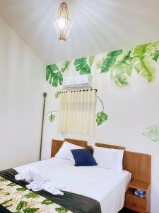1 dormitorio con 1 cama con hojas en la pared en Pousada Bella Vida, en Arraial d'Ajuda