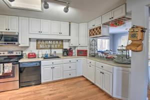 una cocina blanca con armarios y electrodomésticos blancos en New Hampshire Home with Private Beach, Dock and Rafts!, en Barnstead