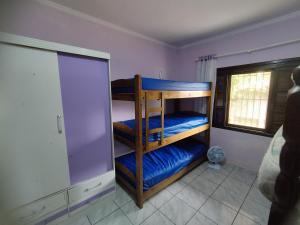 Dos literas en una habitación con sábanas azules. en BONA CASA PERUÍBE, en Peruíbe 54 fotos más