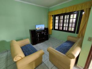 ein Wohnzimmer mit 2 Sofas und einem TV in der Unterkunft BONA CASA PERUÍBE in Peruíbe