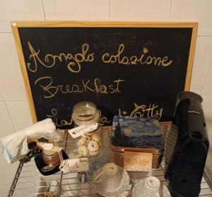 una pizarra con una señal y un estante de comida en La casa di Titty en Villa San Giovanni